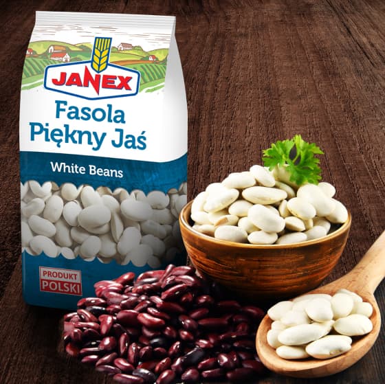 Janex Fasola Piękny Jaś biała fasola w opakowaniu, obok drewniana miska i łyżka z białą fasolą oraz czerwona fasola na ciemnym drewnianym tle, produkt polski.